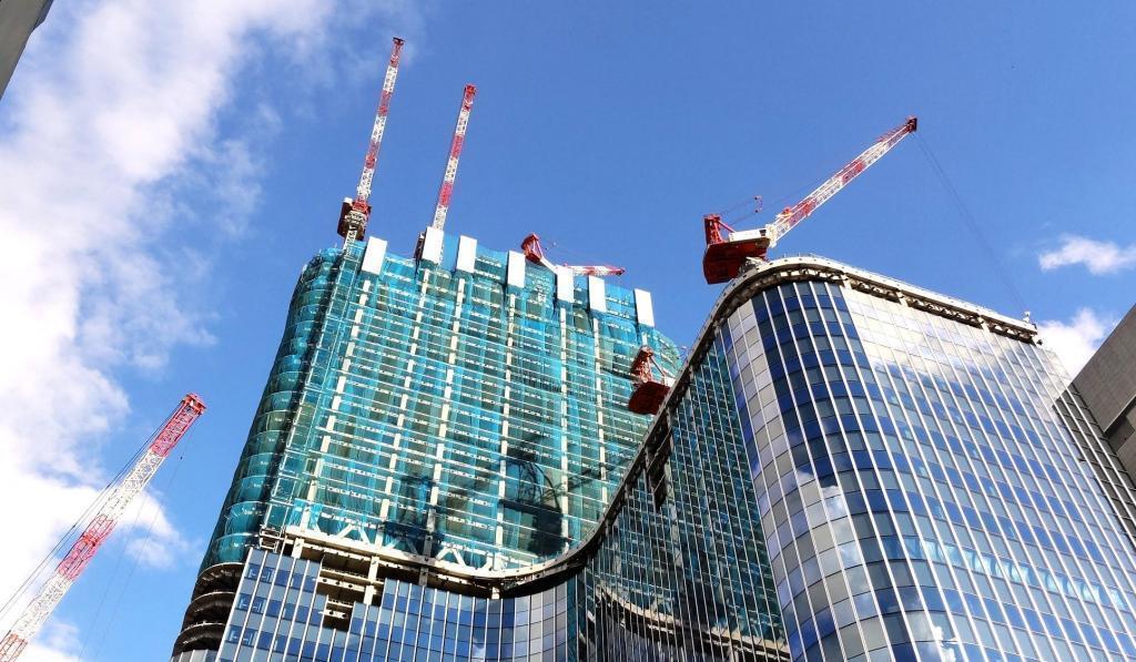  A heavy craftsman standing in the sky: a male figure of a tower crane