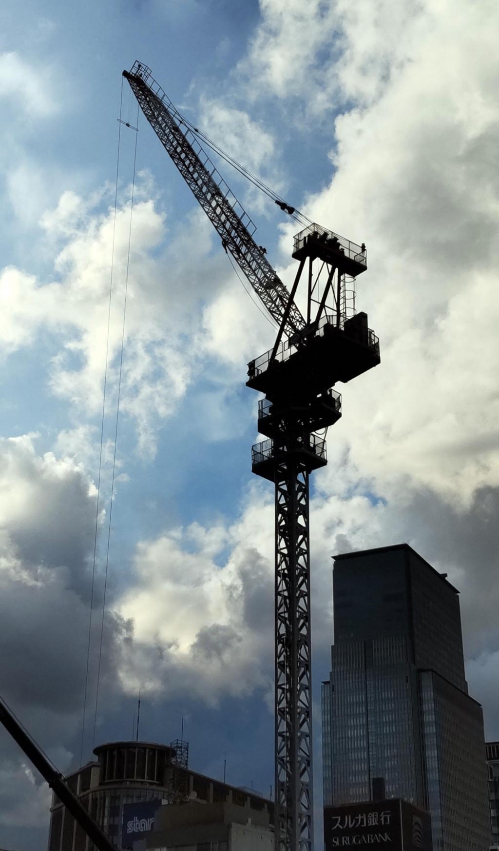  A heavy craftsman standing in the sky: a male figure of a tower crane