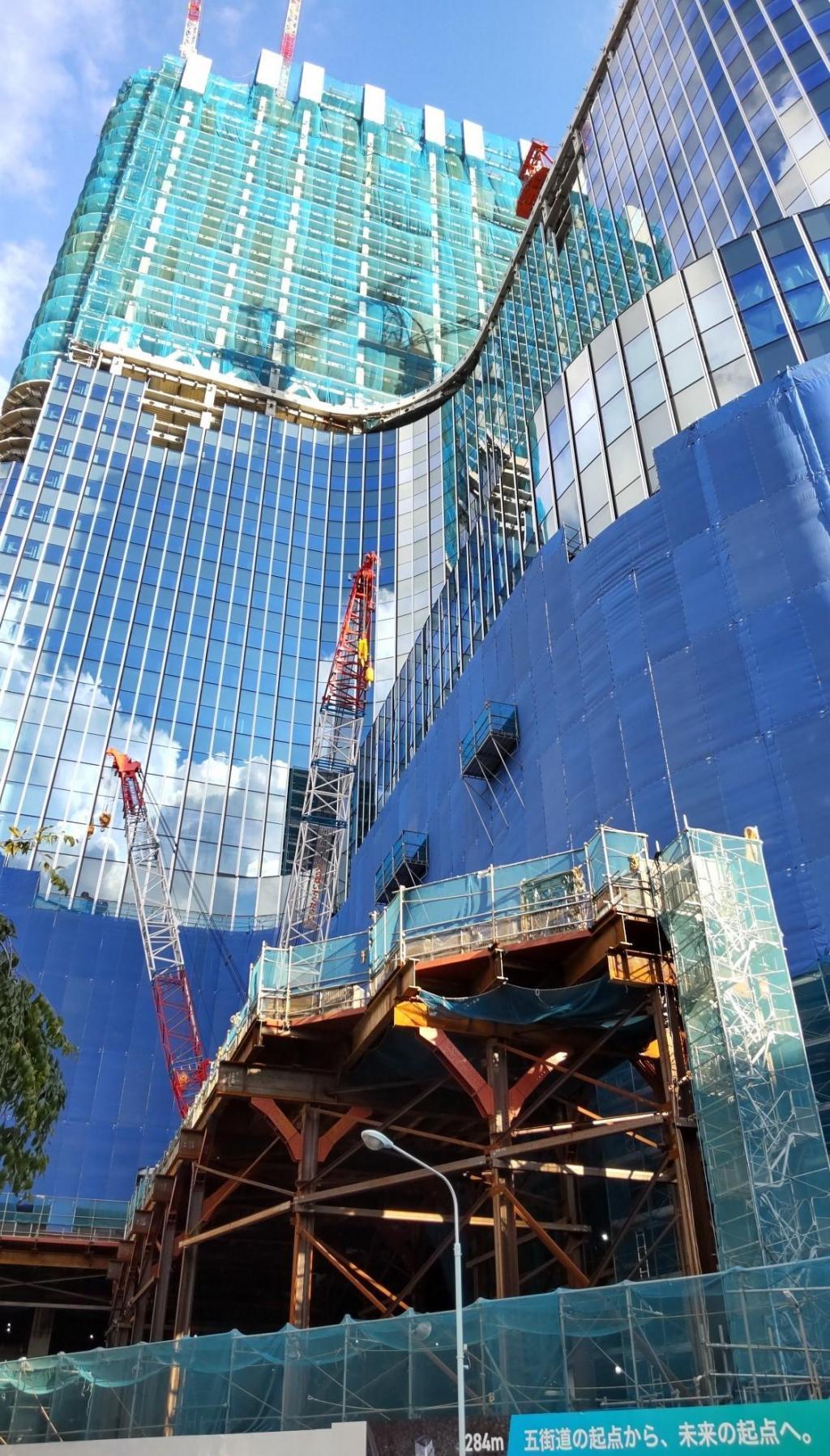  A heavy craftsman standing in the sky: a male figure of a tower crane